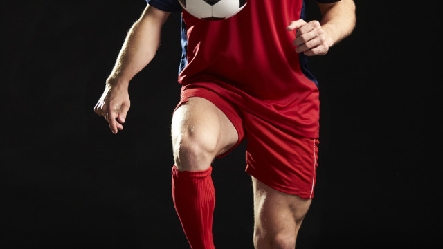 Professional Soccer Player Controlling Ball In Studio